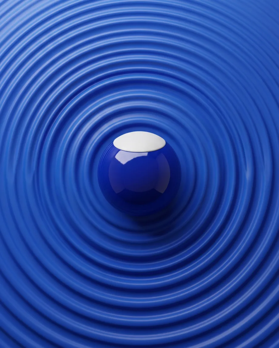 Concentric ripples spreading across a blue surface from a single lacquered marble