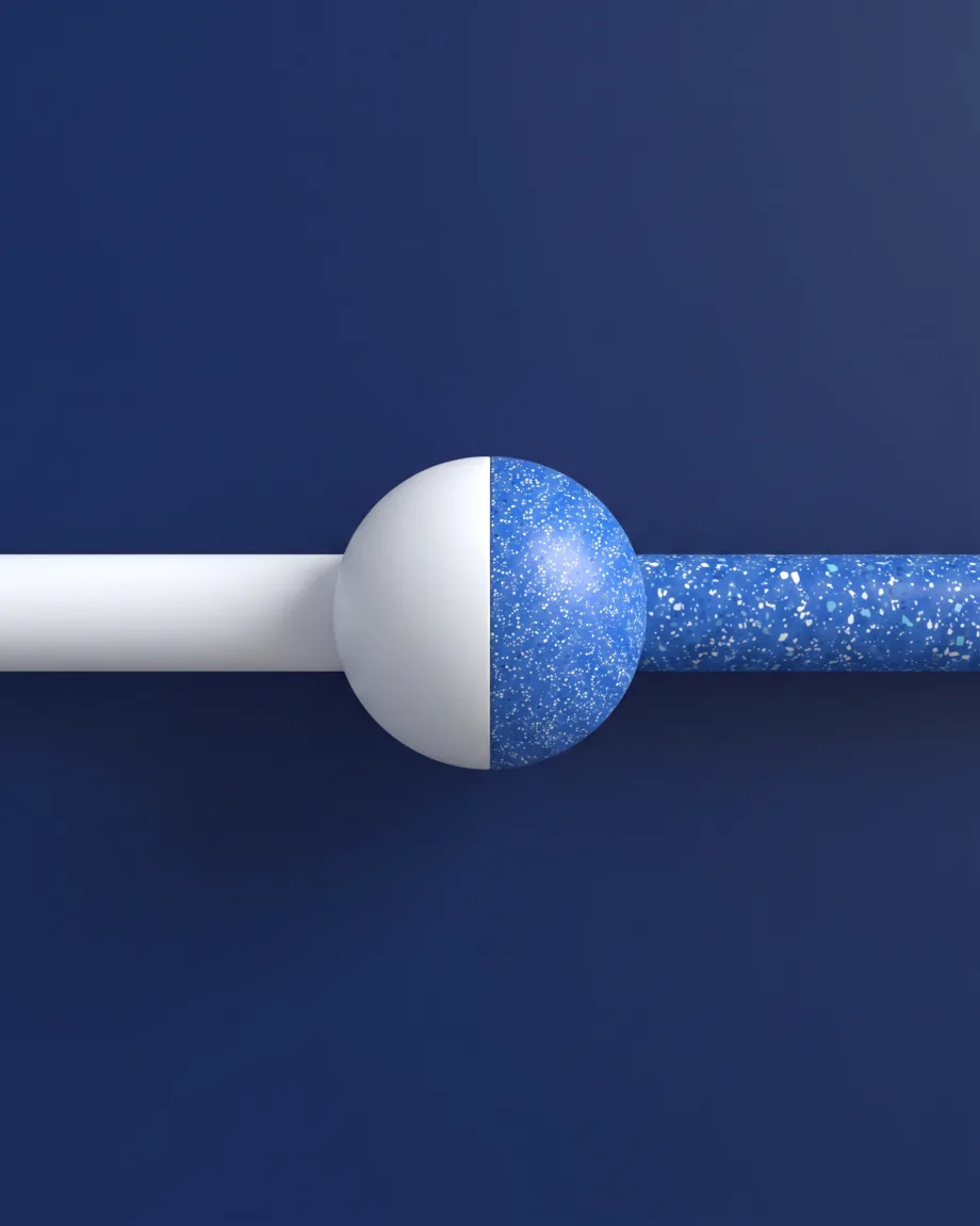 A rail crossing the frame, matte white on one side, blue terrazzo on the other, a marble at the junction